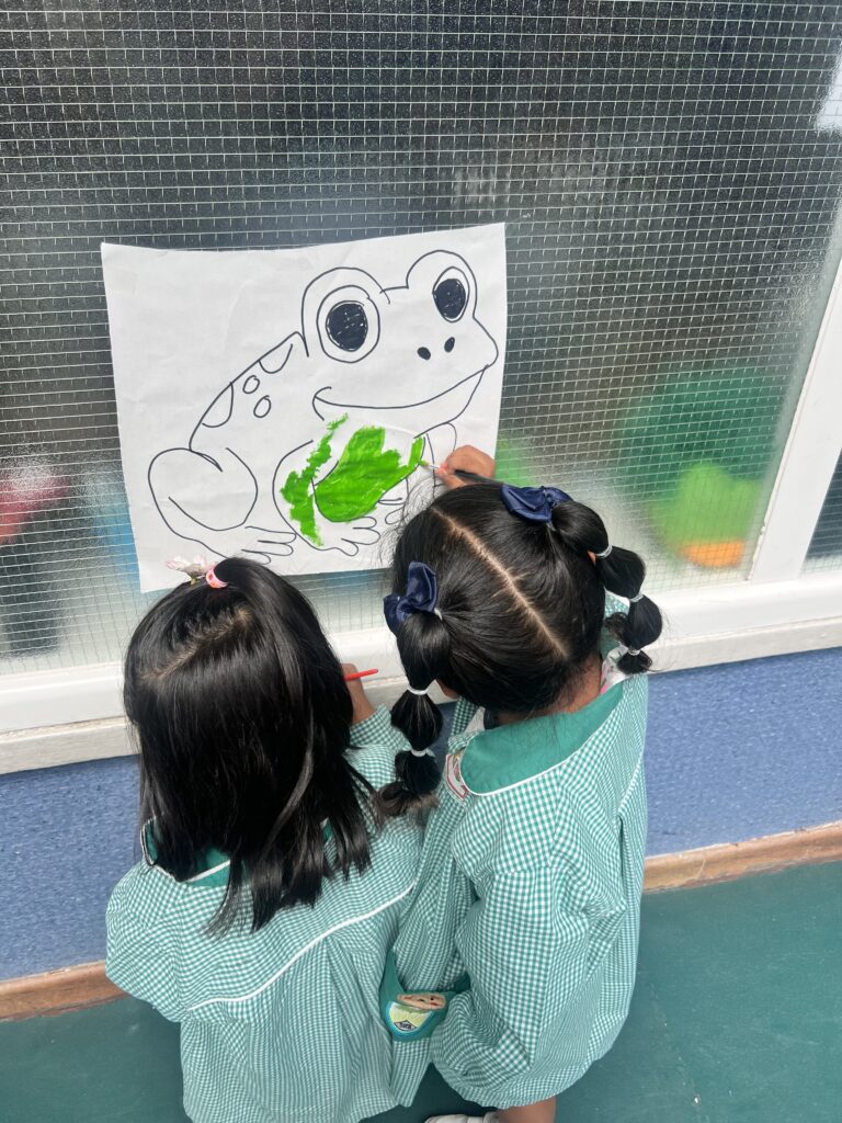 Alumnado de 3 años aprendiendo inglés en el patio con pintura de dedos